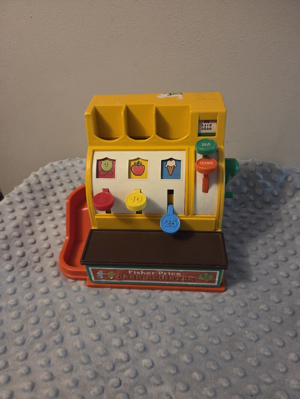 Vintage 1974 Fisher Price cash register with some damage and stickers